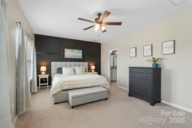 bedroom with baseboards, ceiling fan, light carpet, and connected bathroom