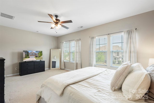 bedroom with baseboards, light carpet, a ceiling fan, and visible vents