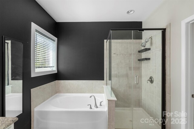 full bathroom featuring a shower stall and a garden tub