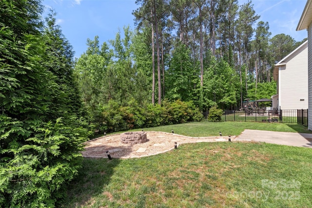 view of yard with fence, a fire pit, and a patio area