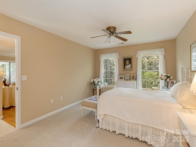 bedroom featuring light colored carpet, baseboards, and multiple windows
