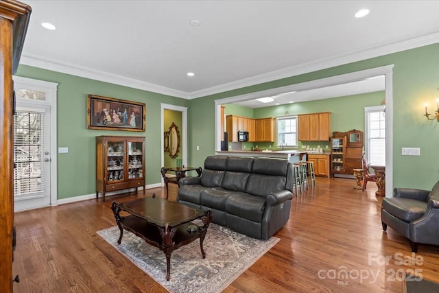 living room with crown molding, recessed lighting, wood finished floors, and baseboards