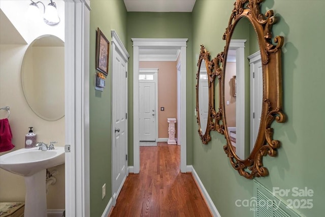 hall with baseboards and wood finished floors
