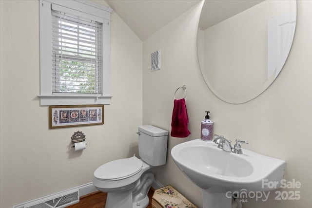 bathroom featuring lofted ceiling, a sink, visible vents, baseboards, and toilet