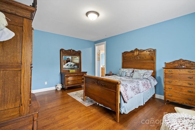 bedroom featuring baseboards and wood finished floors