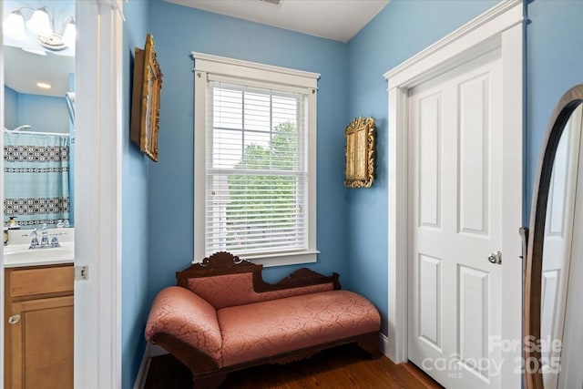living area with baseboards and dark wood-type flooring