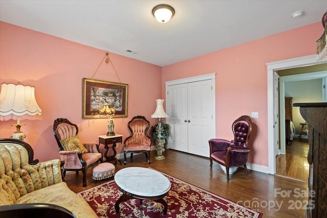 living area with visible vents, wood finished floors, and baseboards