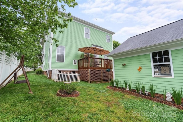 back of house featuring a deck, fence, and a lawn