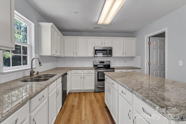 1218 Faversham Ln, Rock Hill, SC 29730 - kitchen featuring appliances with stainless steel finishes, white cabinets, decorative backsplash, and light wood finished floors