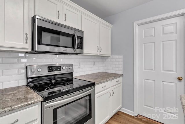 1218 Faversham Ln, Rock Hill, SC 29730 - kitchen with stainless steel appliances, white cabinetry, light stone counters, light wood-style flooring, and decorative backsplash