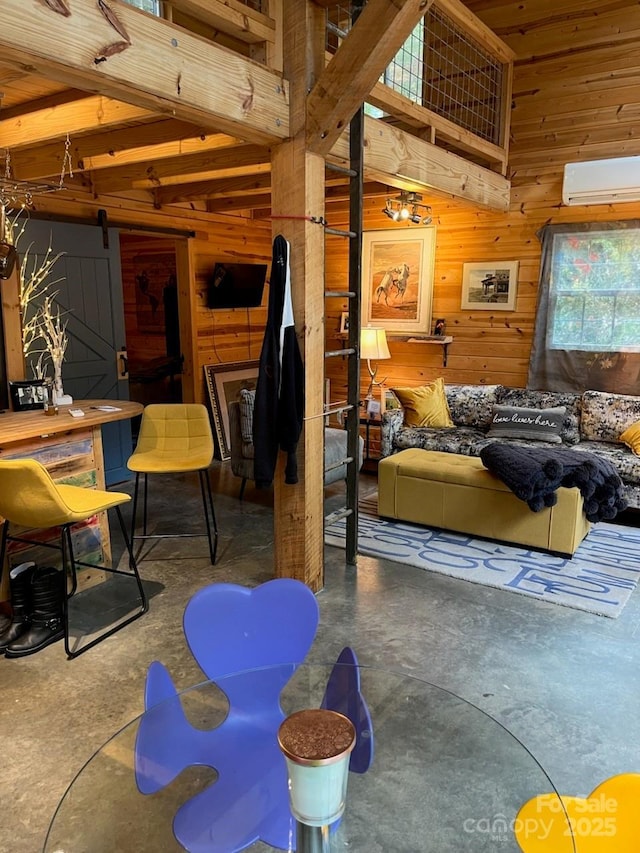 living area featuring wooden walls, concrete floors, and a wall mounted AC