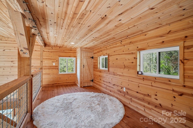 additional living space featuring lofted ceiling, wood ceiling, wood walls, and wood-type flooring