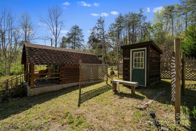 view of yard with a storage unit, fence, and an outdoor structure