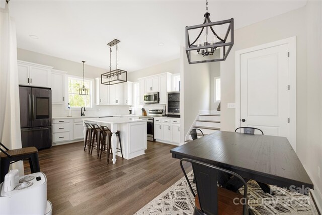 5028 Lewis Rd, Gastonia, NC 28052 - kitchen with appliances with stainless steel finishes, a chandelier, dark wood-style flooring, and white cabinets