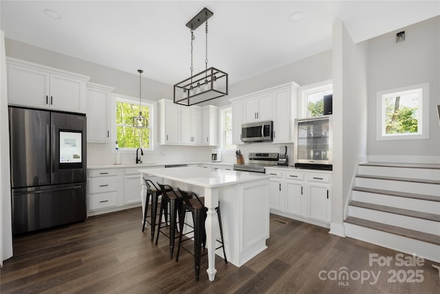 5028 Lewis Rd, Gastonia, NC 28052 - kitchen with stainless steel appliances, white cabinets, backsplash, and dark wood-style floors