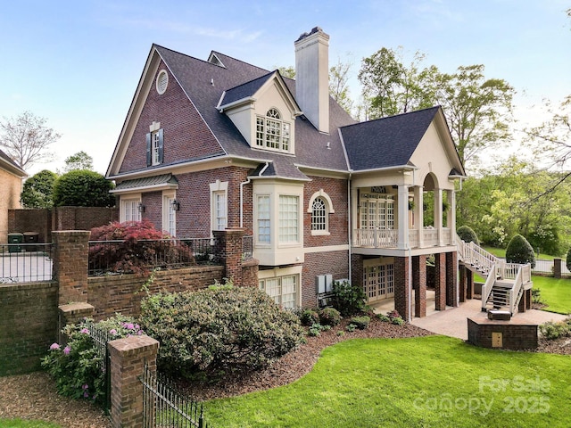4324 Doverstone Ln, Greensboro, NC 27407 - rear view of property with a lawn, brick siding, fence, a patio, and stairs