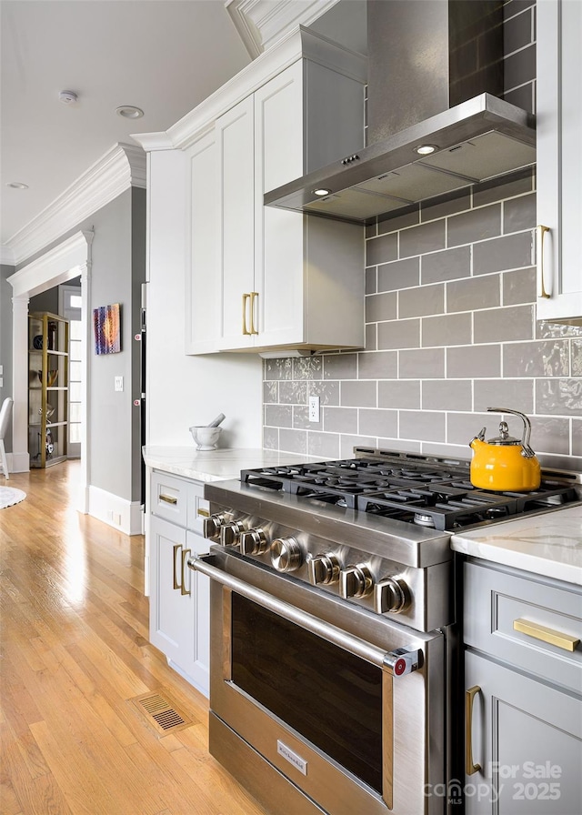 4324 Doverstone Ln, Greensboro, NC 27407 - kitchen featuring crown molding, high end stainless steel range, baseboards, wall chimney exhaust hood, and backsplash