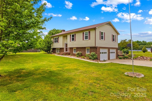 split foyer home featuring a garage, a front lawn, a chimney, brick siding, and driveway