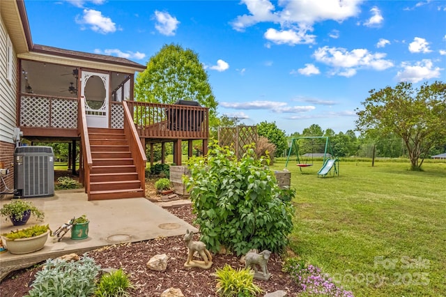 view of playground with ceiling fan, stairs, central AC unit, a patio area, and a yard