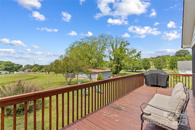 wooden deck with area for grilling and a yard