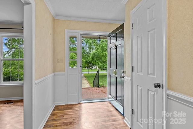 101 Wynnchester Rd, Gastonia, NC 28056 - doorway to outside featuring crown molding, wainscoting, a textured ceiling, wood finished floors, and visible vents
