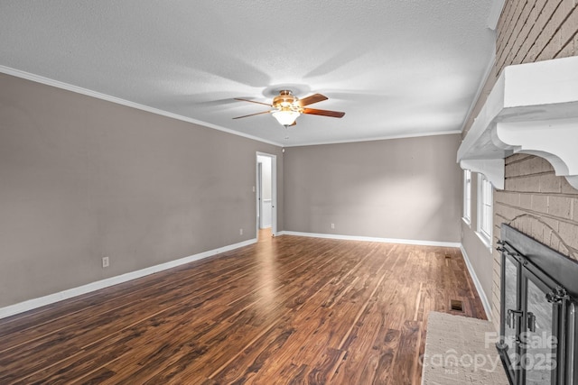 101 Wynnchester Rd, Gastonia, NC 28056 - unfurnished living room featuring a brick fireplace, a textured ceiling, a ceiling fan, baseboards, and wood finished floors