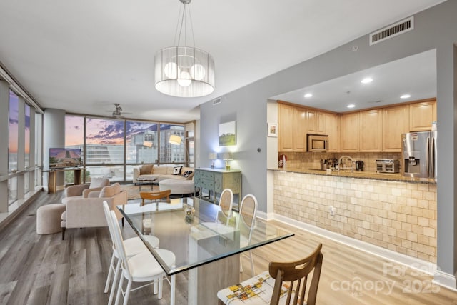 315 Arlington Ave Unit 1104, Charlotte, NC 28203 - dining area featuring visible vents, ceiling fan, light wood finished floors, and baseboards