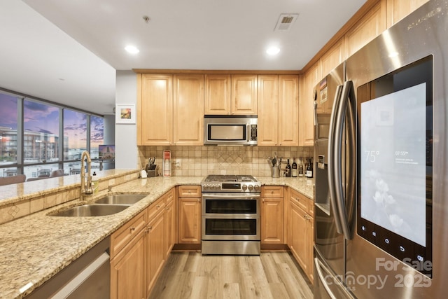 315 Arlington Ave Unit 1104, Charlotte, NC 28203 - kitchen with light wood finished floors, a sink, tasteful backsplash, light stone counters, and appliances with stainless steel finishes