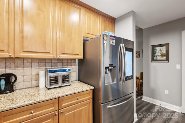 315 Arlington Ave Unit 1104, Charlotte, NC 28203 - kitchen with dark wood-type flooring, baseboards, light stone countertops, stainless steel refrigerator with ice dispenser, and backsplash