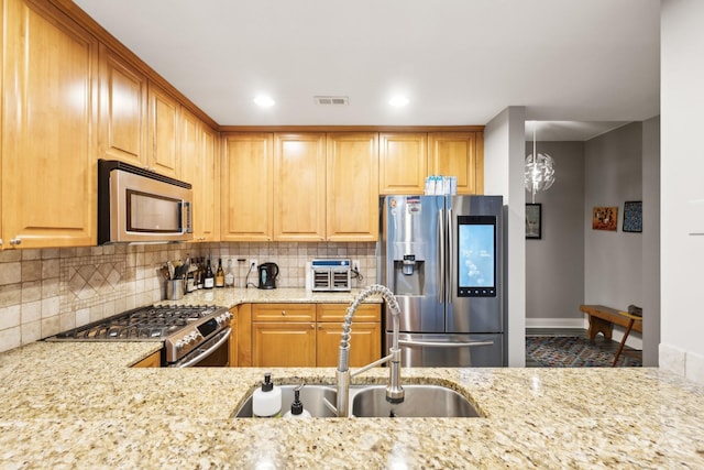 315 Arlington Ave Unit 1104, Charlotte, NC 28203 - kitchen with tasteful backsplash, a sink, appliances with stainless steel finishes, baseboards, and light stone countertops