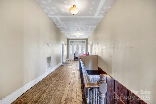 hallway featuring visible vents and hardwood / wood-style flooring