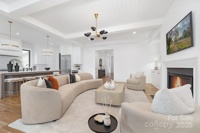632 Dorothy Dr, Charlotte, NC 28203 - living room with light wood-style floors, beam ceiling, a chandelier, a glass covered fireplace, and recessed lighting