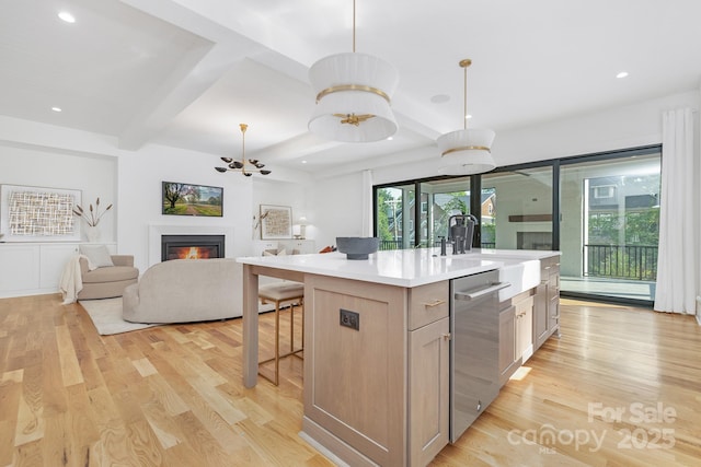 632 Dorothy Dr, Charlotte, NC 28203 - kitchen with stainless steel dishwasher, light wood-type flooring, a sink, a warm lit fireplace, and beamed ceiling