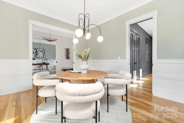 632 Dorothy Dr, Charlotte, NC 28203 - dining space with a wainscoted wall, light wood-style floors, crown molding, and a decorative wall