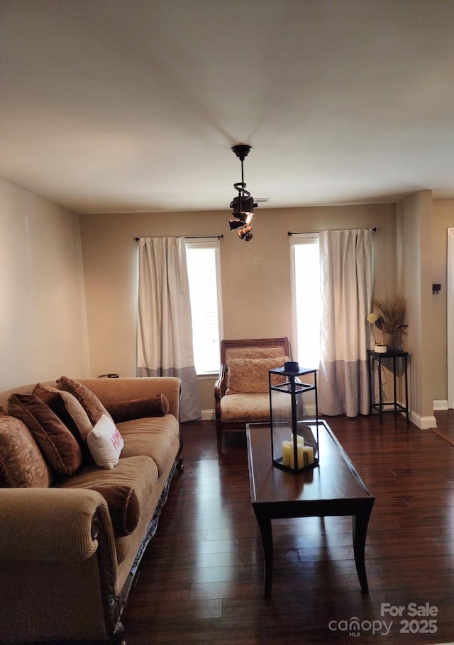 living room with baseboards, dark wood-style floors, and plenty of natural light