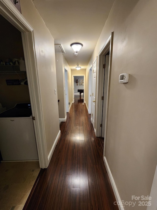 hall featuring attic access, baseboards, and wood-type flooring