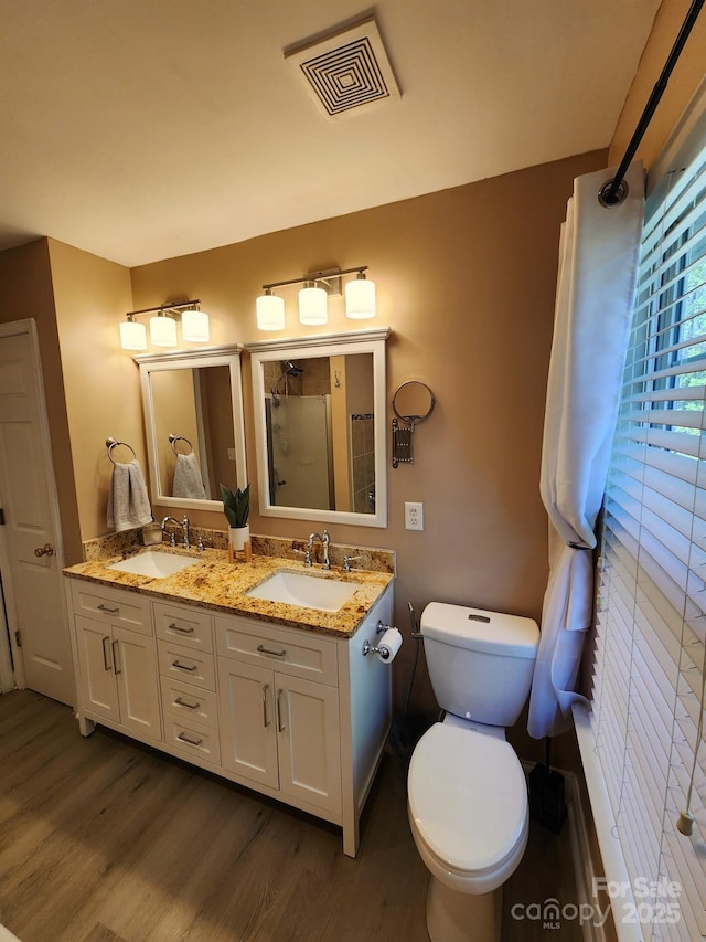 full bathroom featuring a sink, visible vents, and wood finished floors