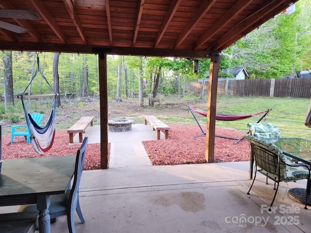 view of patio with an outdoor fire pit and fence