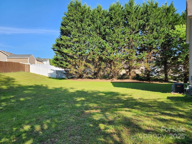 view of yard featuring central AC unit and fence