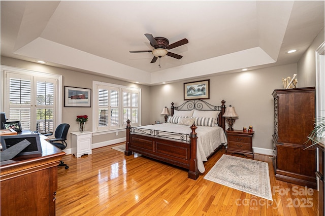 5933 Flintlock Ct, Hickory, NC 28601 - bedroom featuring a tray ceiling, baseboards, light wood-style floors, multiple windows, and recessed lighting