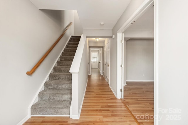 stairway featuring baseboards and wood finished floors