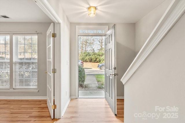 entryway with baseboards, visible vents, and light wood-style floors
