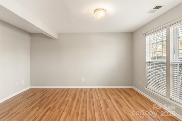 empty room with baseboards, visible vents, and light wood-style flooring