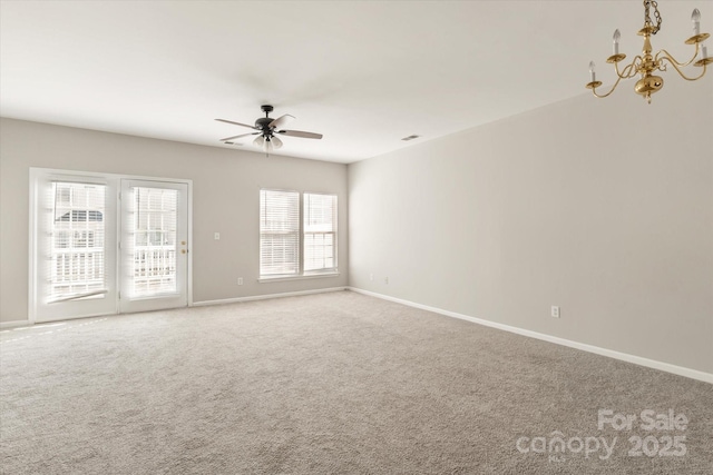 spare room with carpet floors, baseboards, and ceiling fan with notable chandelier