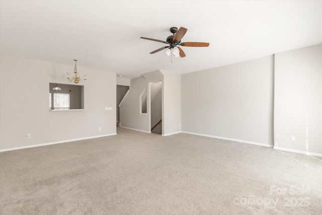 spare room with baseboards, carpet flooring, and ceiling fan with notable chandelier