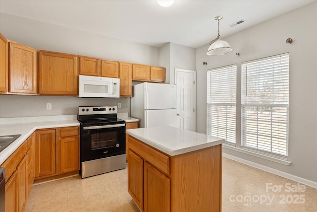 kitchen featuring hanging light fixtures, light countertops, a center island, stainless steel appliances, and visible vents