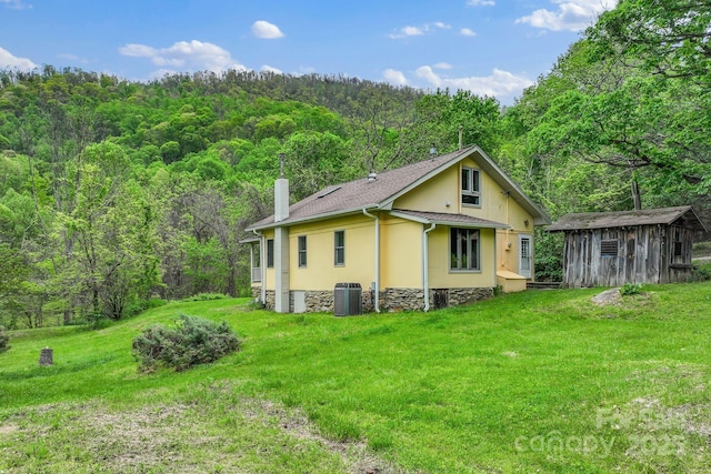 443 Ox Creek Rd, Weaverville, NC 28787 - view of side of home with a forest view, a lawn, a chimney, and an outdoor structure