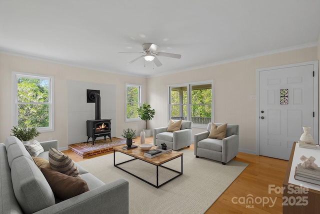 443 Ox Creek Rd, Weaverville, NC 28787 - living room featuring a wood stove, ceiling fan, plenty of natural light, light wood-style flooring, and crown molding