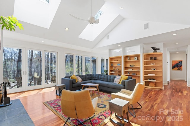 living room featuring recessed lighting, a skylight, wood finished floors, and high vaulted ceiling