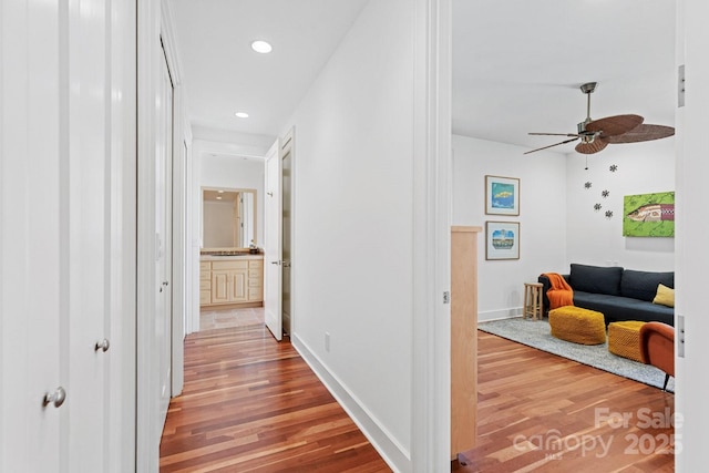 hallway featuring recessed lighting, baseboards, and wood finished floors